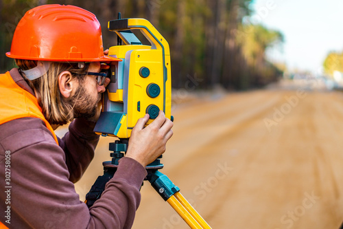 Fotografie Surveyor engineer with equipment (theodolite or total positioning station) on th