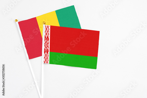 Belarus and Guinea stick flags on white background. High quality fabric, miniature national flag. Peaceful global concept.White floor for copy space. photo