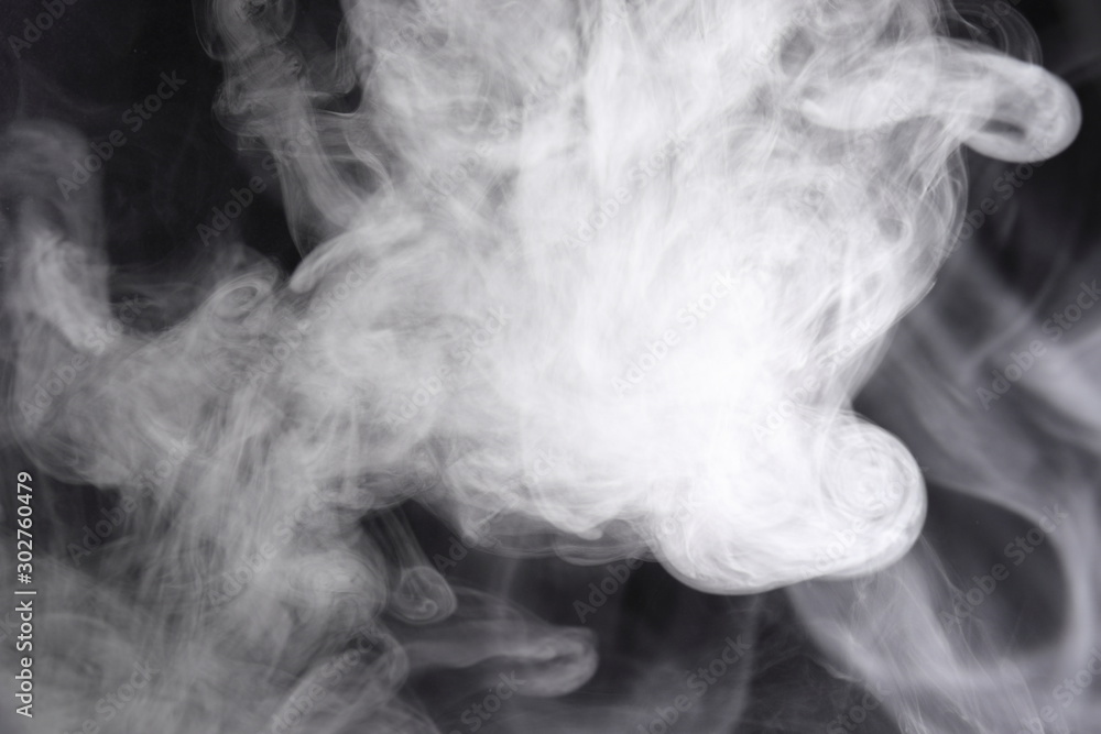 Puffs of white, gray smoke spread on a black background, curling in a fancy dance. Puffs of white, gray smoke spread on a black background, curling in a fancy dance.