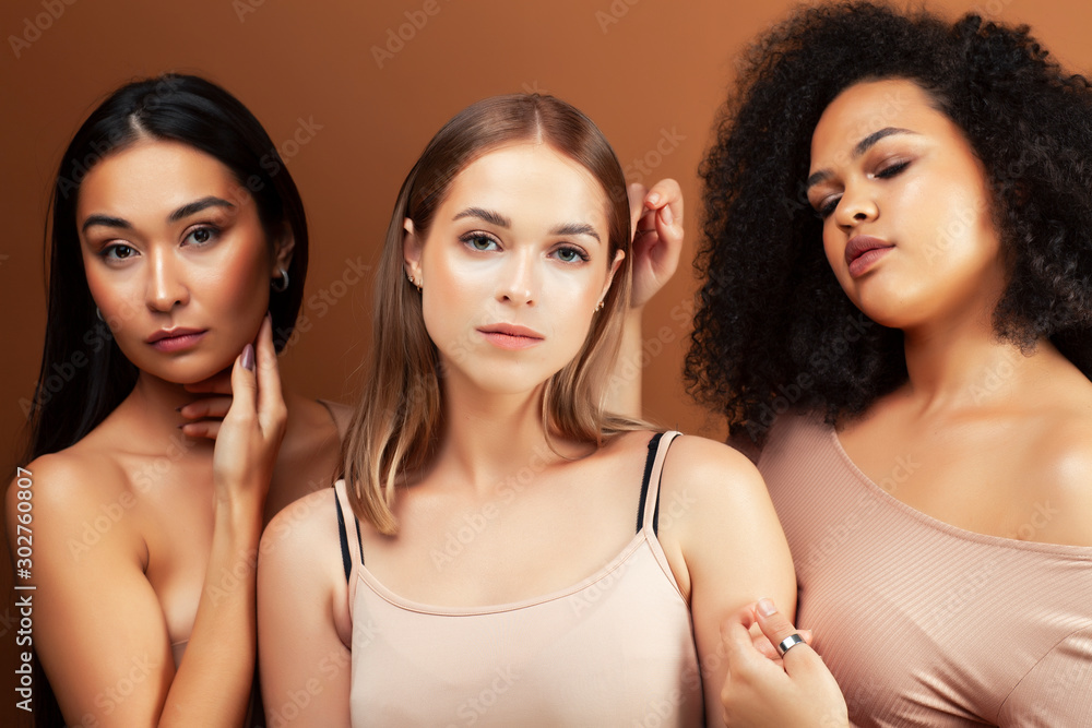 young pretty asian, caucasian, afro woman posing cheerful together on brown background, lifestyle diverse nationality people concept young pretty asian, caucasian, afro woman posing cheerful together on brown background, lifestyle diverse nationality people concept