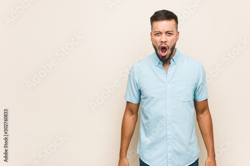 Young south-asian man screaming very angry and aggressive.