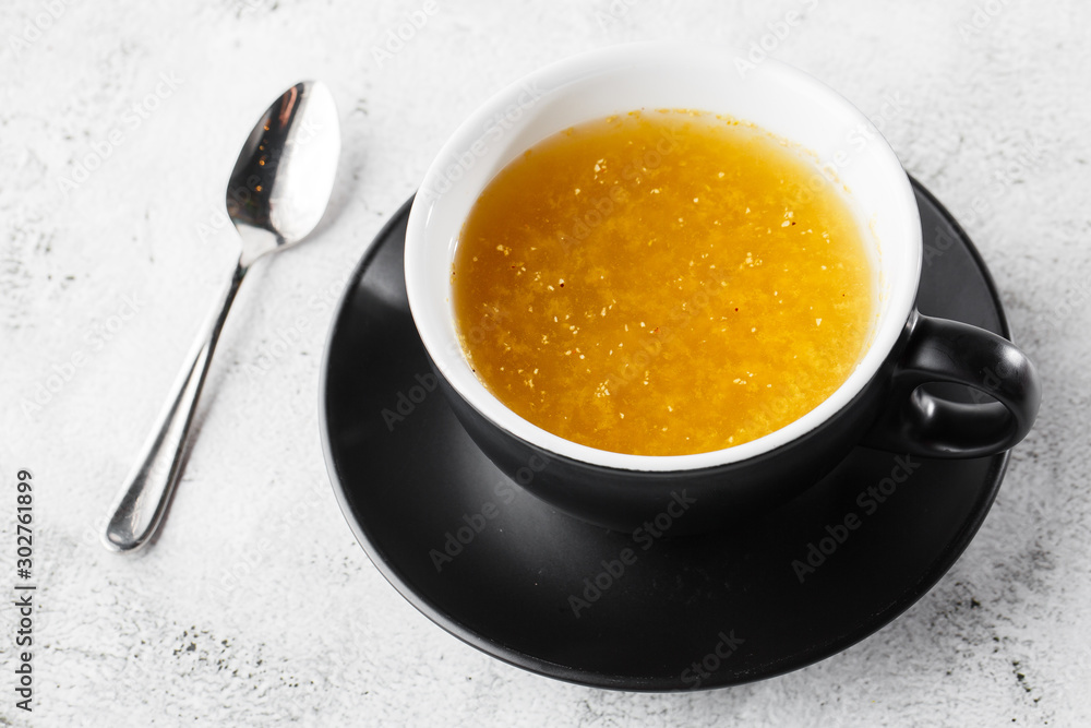 Sea buckthorn tea in dark cup isolated on bright marble background. Overhead view, copy space. Advertising for cafe menu. Coffee shop menu. Horizontal photo. Sea buckthorn tea in dark cup isolated on bright marble background. Overhead view, copy space. Advertising for cafe menu. Coffee shop menu. Horizontal photo.