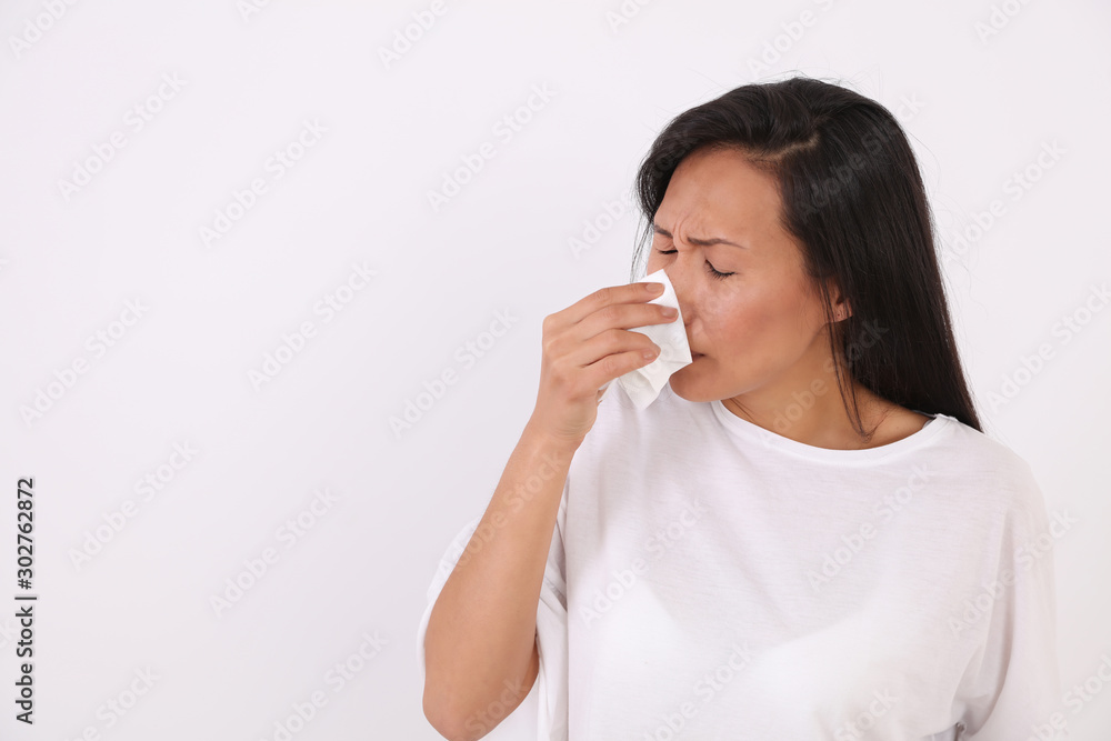 Sick Woman sneezing in to tissue/ Blowing Her Nose In Handkerchief. Flu / Allergy concept Sick Woman sneezing in to tissue/ Blowing Her Nose In Handkerchief. Flu / Allergy concept