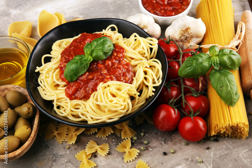 Tasty appetizing classic italian spaghetti pasta with tomato sauce, cheese parmesan and basil and ingredients