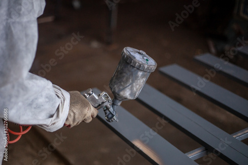 Painting a tree from a spray gun. Paint in the workshop.