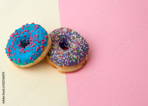 round baked donut with colored sugar sprinkles and with blue sugar glaze