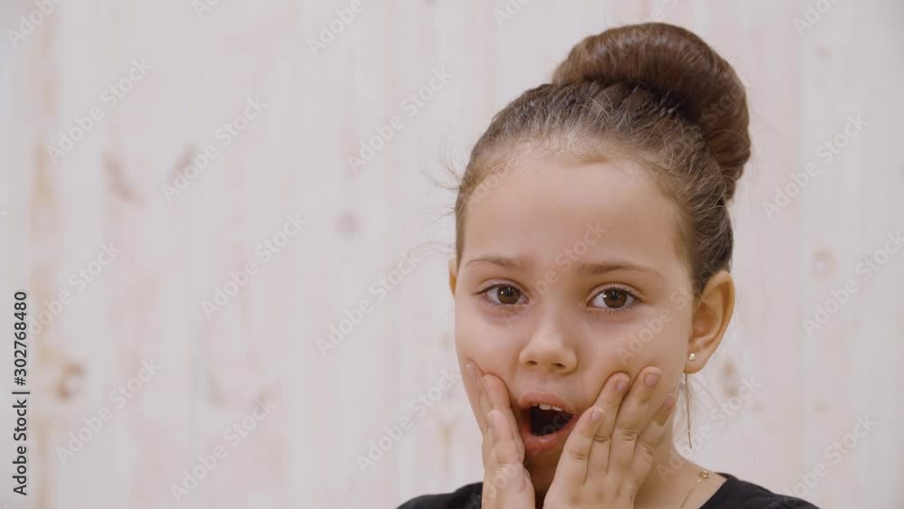 Close-up view of surprised little girl looking at camera. Portrait of ...