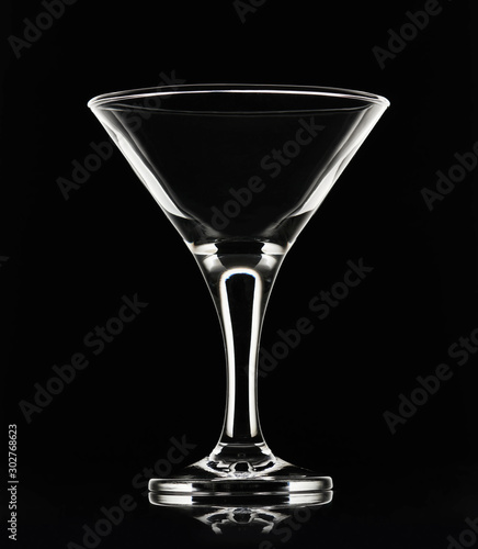 White silhouette of empty martini cocktail glass on a black background