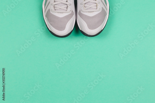 Grey sneakers on the turquoise background. Concept for healthy lifestyle and everyday training.