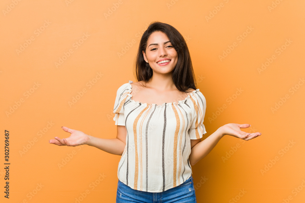 Young curvy woman showing a welcome expression.