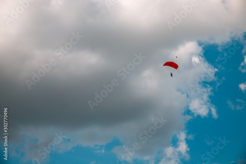 Paratrooper parachuting in blue sky. Military service