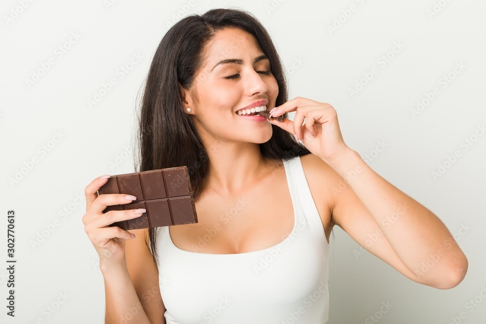 Young hispanic woman holding a chocolate tablet Young hispanic woman holding a chocolate tablet