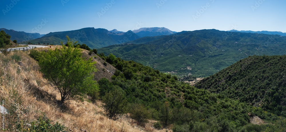 Panoramic landscape with asphalt road and mountains over blue clear sky. Road leads to the monasteries on the top of Meteora , Greece