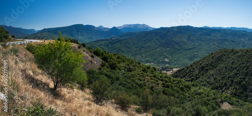 Panoramic landscape with asphalt road and mountains over blue clear sky. Road leads to the monasteries on the top of Meteora , Greece