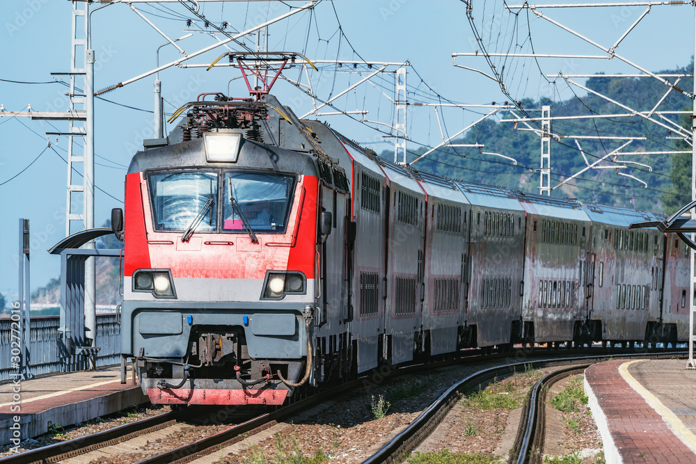 Naklejka premium Passenger double deck train moves along the platform by Black Sea.