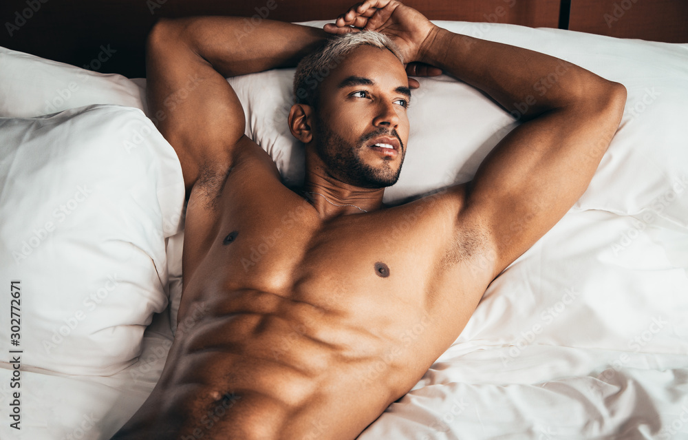 Sexy man in bed in hotel room Stock Photo | Adobe Stock