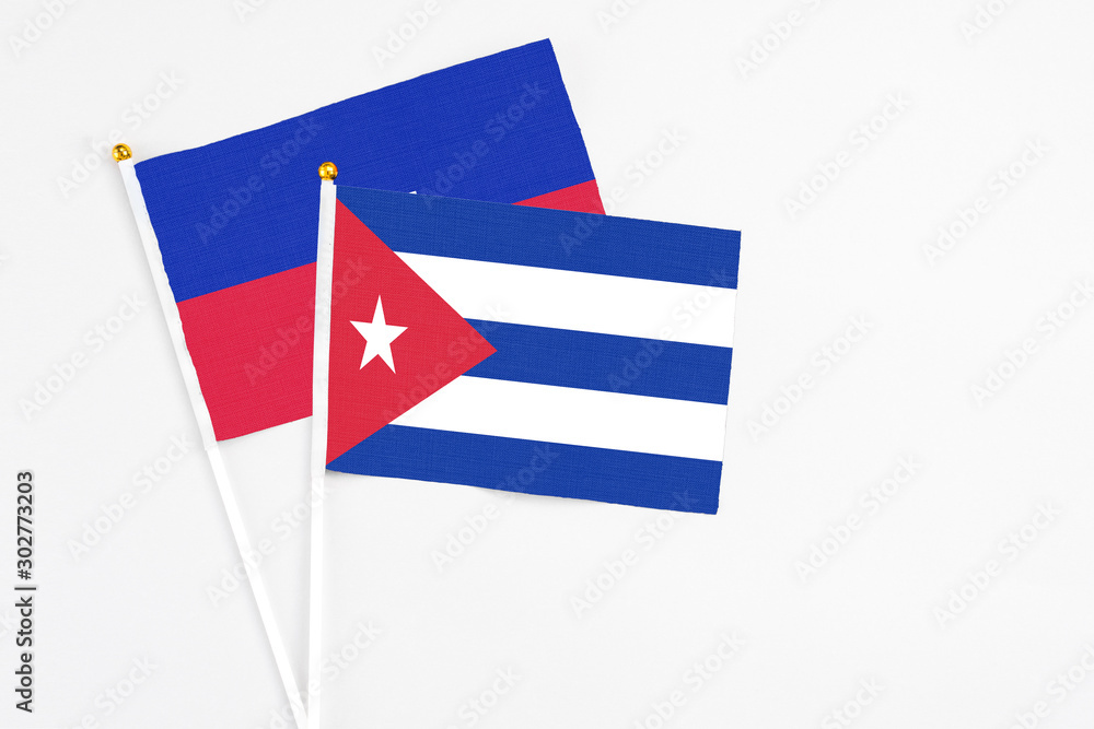 Cuba and Haiti stick flags on white background. High quality fabric, miniature national flag. Peaceful global concept.White floor for copy space.