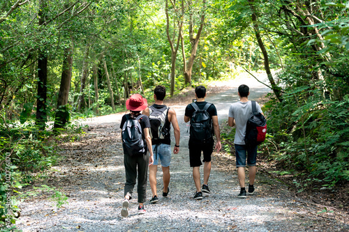 Group Of Friends hiking together through the forest © pigprox