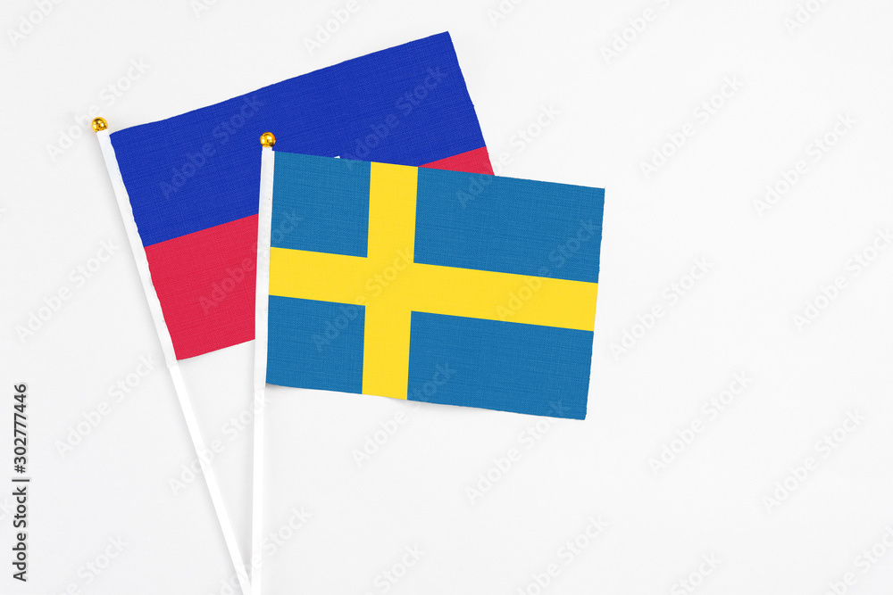 Sweden and Haiti stick flags on white background. High quality fabric, miniature national flag. Peaceful global concept.White floor for copy space. Sweden and Haiti stick flags on white background. High quality fabric, miniature national flag. Peaceful global concept.White floor for copy space.