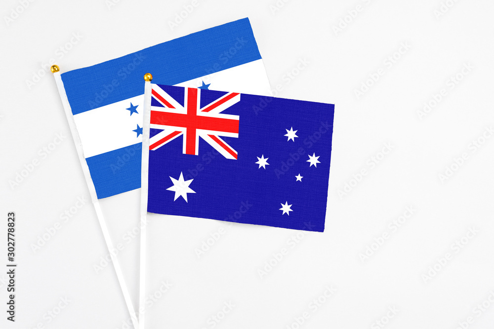 Fototapeta premium Australia and Honduras stick flags on white background. High quality fabric, miniature national flag. Peaceful global concept.White floor for copy space.