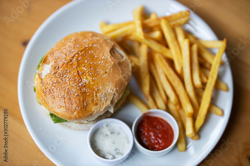 tasty hamburger with french fries on table