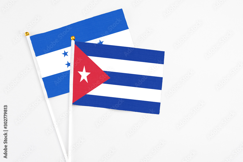 Cuba and Honduras stick flags on white background. High quality fabric, miniature national flag. Peaceful global concept.White floor for copy space. Cuba and Honduras stick flags on white background. High quality fabric, miniature national flag. Peaceful global concept.White floor for copy space.