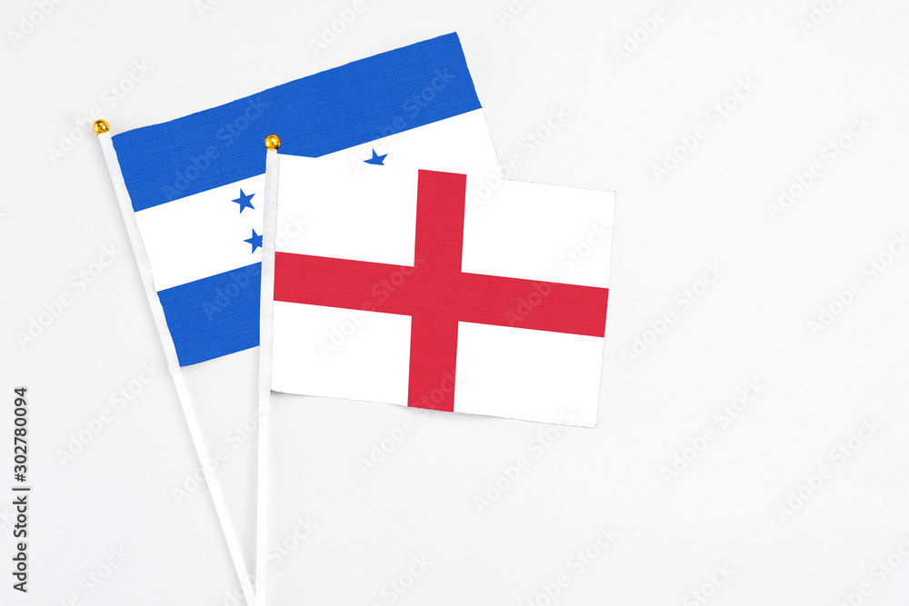 England and Honduras stick flags on white background. High quality fabric, miniature national flag. Peaceful global concept.White floor for copy space.