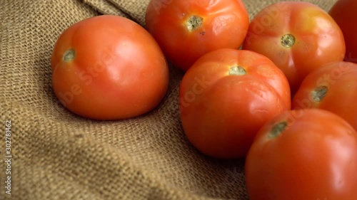 Red tomatoes rotating on a jute mat
