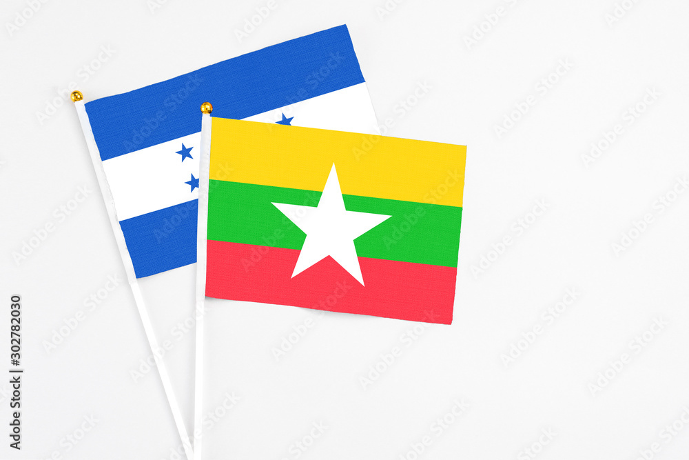 Myanmar and Honduras stick flags on white background. High quality fabric, miniature national flag. Peaceful global concept.White floor for copy space. Myanmar and Honduras stick flags on white background. High quality fabric, miniature national flag. Peaceful global concept.White floor for copy space.