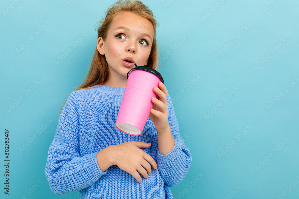 portrait of a pensive beautiful girl with a glass of coffee on a blue background portrait of a pensive beautiful girl with a glass of coffee on a blue background