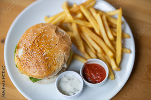 tasty hamburger with french fries on table