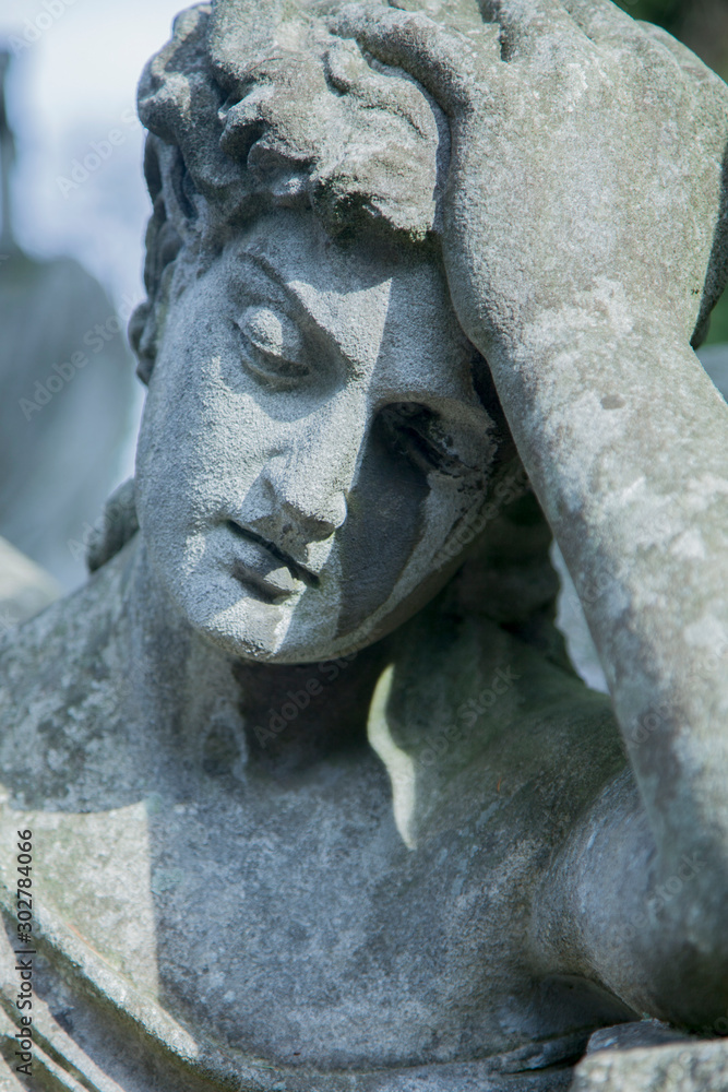 Obraz premium Close up statue of sad man on tomb as a symbol of depression, pain and sorrow.