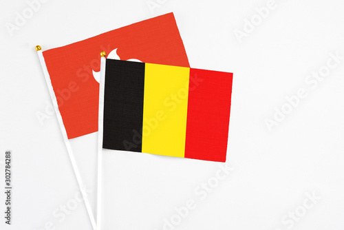 Belgium and Hong Kong stick flags on white background. High quality fabric, miniature national flag. Peaceful global concept.White floor for copy space. photo