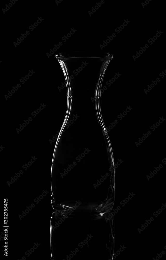 Empty bottle or decanter isolated on a dark background Empty bottle or decanter isolated on a dark background