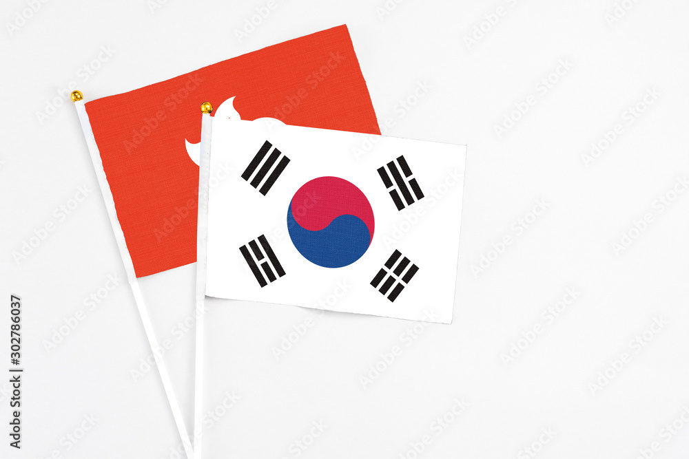 South Korea and Hong Kong stick flags on white background. High quality fabric, miniature national flag. Peaceful global concept.White floor for copy space.