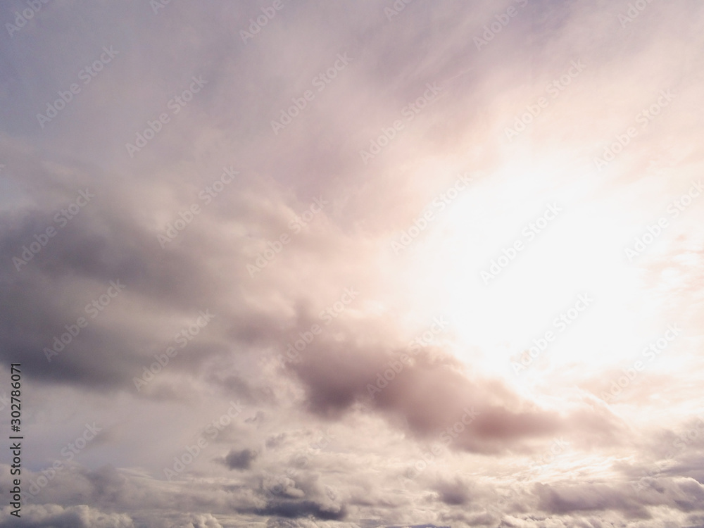 Abstract nature background, Cloudy sky, Sun shines through, flare and rays of light.