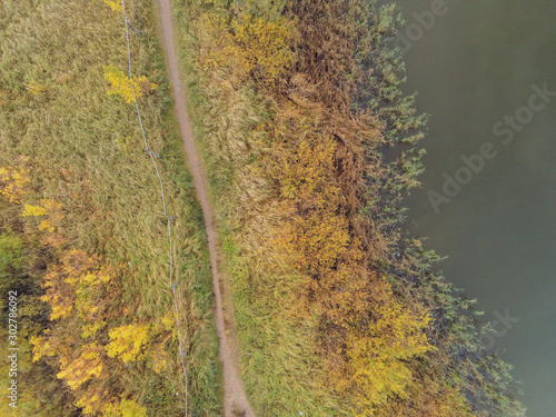 River aerial top view. Water surface and green vegetation on the bank, Small walking path and metal fence. © mark_gusev