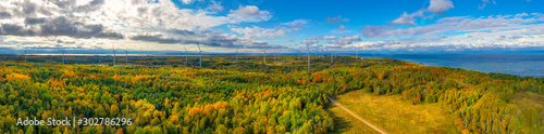 The Windmills park of Paldiski. Wind turbine farm near Baltic sea. Autumn landscape with windmills, orange forest and blue sky. Pakri peninsula, Estonia, Europe