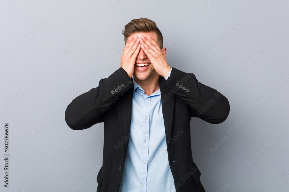 Young handsome caucasian man covers eyes with hands, smiles broadly waiting for a surprise. Young handsome caucasian man covers eyes with hands, smiles broadly waiting for a surprise.