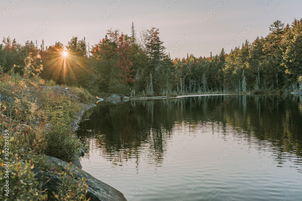 Φωτογραφία Kayaking in Boreas Ponds in the Adirondacks on a glassy lake with Mount Marcy and the high peaks in the background as the sun is setting