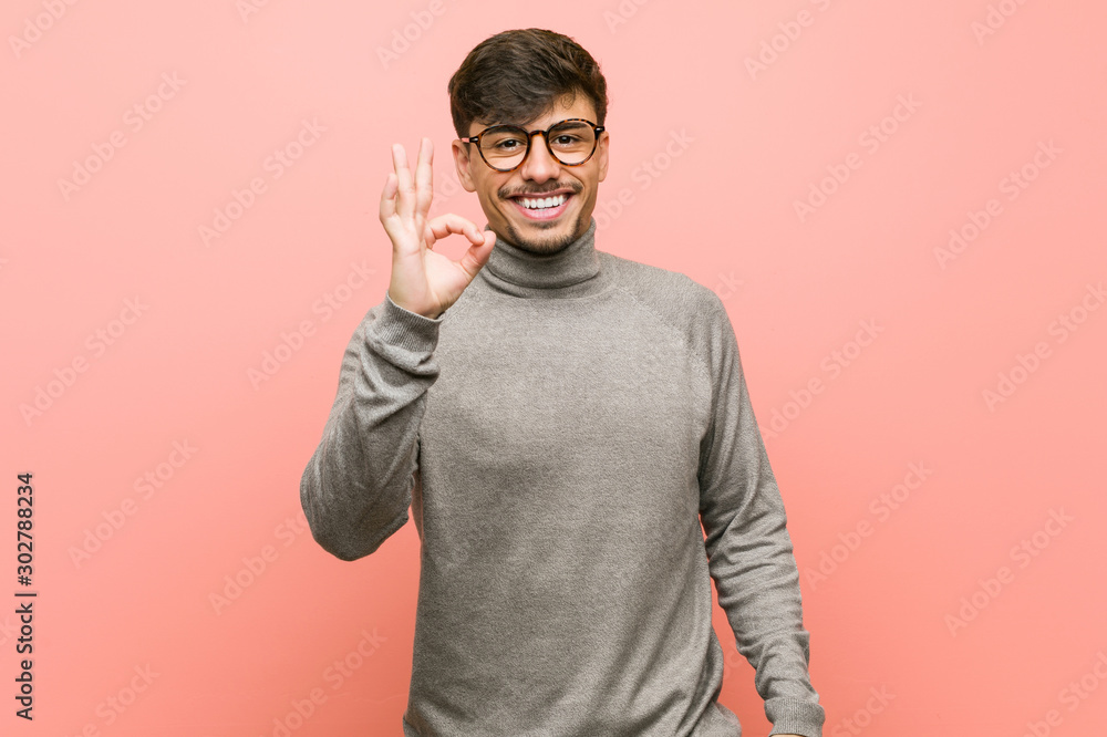 Young smart student man cheerful and confident showing ok gesture. Young smart student man cheerful and confident showing ok gesture.