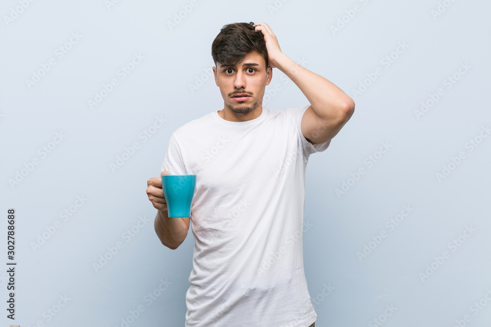 Young hispanic man holding a cup being shocked, she has remembered important meeting. Young hispanic man holding a cup being shocked, she has remembered important meeting.