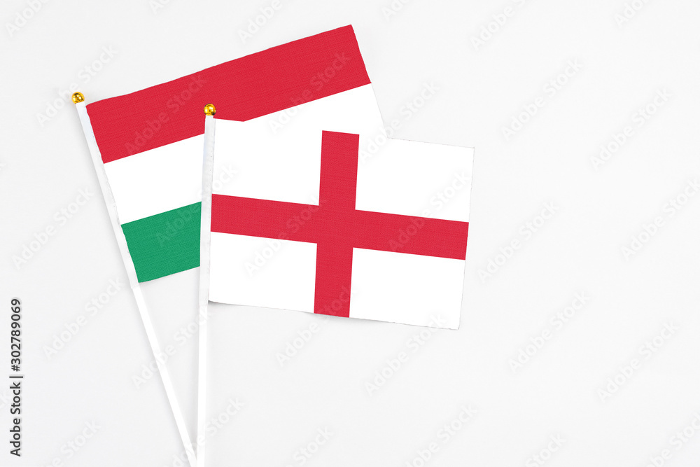 England and Hungary stick flags on white background. High quality fabric, miniature national flag. Peaceful global concept.White floor for copy space.