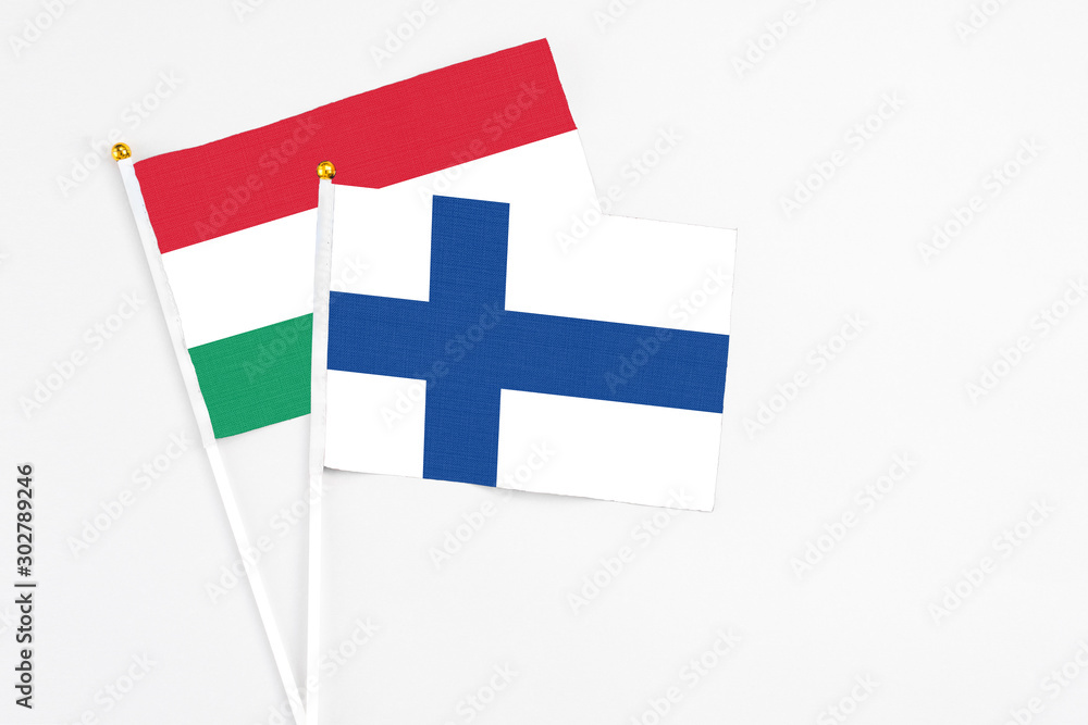 Finland and Hungary stick flags on white background. High quality fabric, miniature national flag. Peaceful global concept.White floor for copy space.
