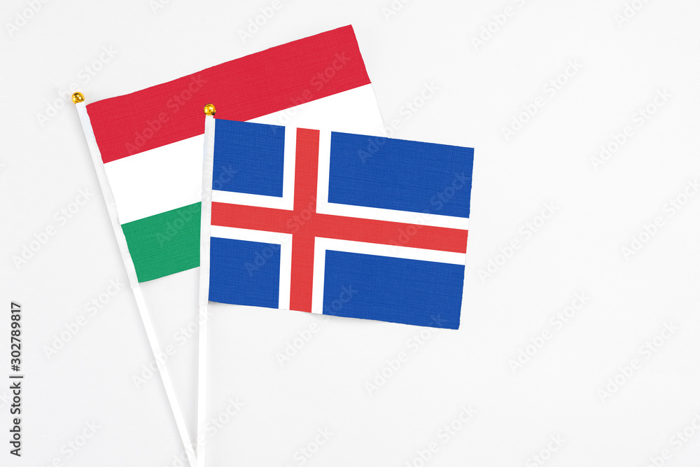 Iceland and Hungary stick flags on white background. High quality fabric, miniature national flag. Peaceful global concept.White floor for copy space.