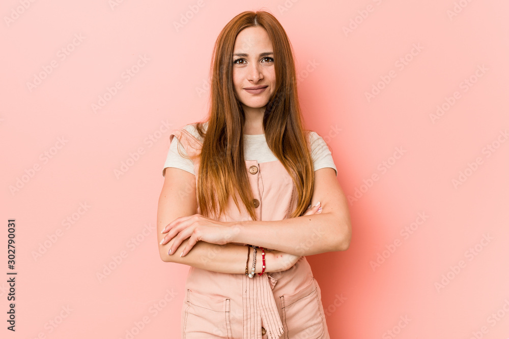 Young ginger woman with freckles who feels confident, crossing arms with determination. Young ginger woman with freckles who feels confident, crossing arms with determination.