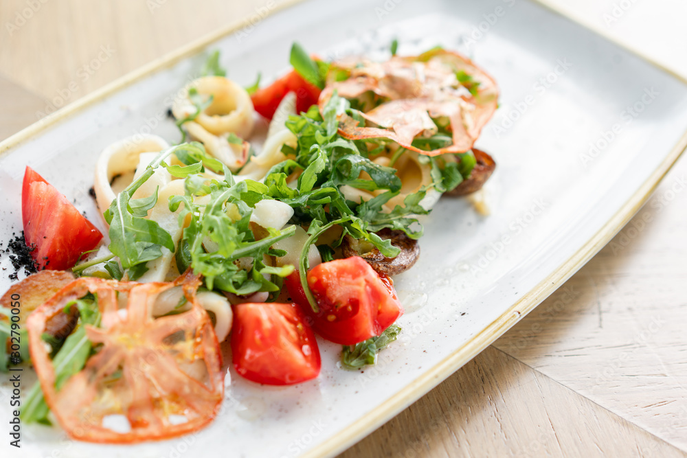 Fresh Salad with tomatoes, basil, mozzarella, and olive oil on wooden background. Italian traditional caprese salad. Mediterranean, natural and organic food concept. Fresh Salad with tomatoes, basil, mozzarella, and olive oil on wooden background. Italian traditional caprese salad. Mediterranean, natural and organic food concept.