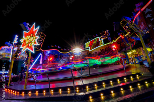 Ferris wheel in motion in the amusement park, at night. Long exposure photography.