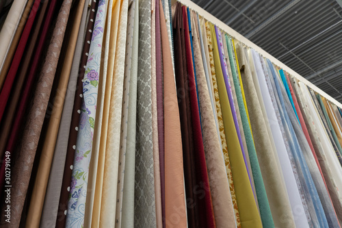 fabrics hang on a counter in a fabric store. assortment of fabrics