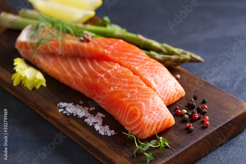 Fresh raw salmon fish fillet, asparagus, lemon, herbs and spices